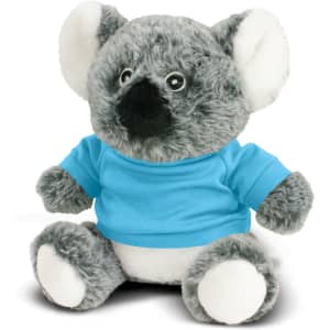 A grey koala plush toy wearing a blue shirt, sitting with a soft white belly and large ears. It has a small branding logo.