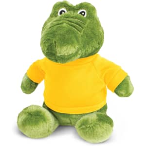 A green crocodile plush toy wearing a yellow shirt, with round eyes and a soft, cuddly appearance.