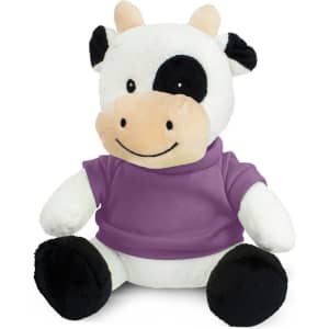 A plush cow toy in black and white, wearing a purple shirt, sitting with a cheerful expression.