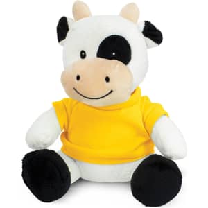 A cow plush toy with black and white fur, wearing a yellow shirt, sitting upright with a friendly smile.