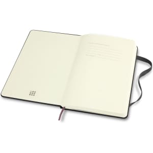 An open medium-sized Moleskine Classic Hard Cover Notebook with a black cover and blank cream pages.
