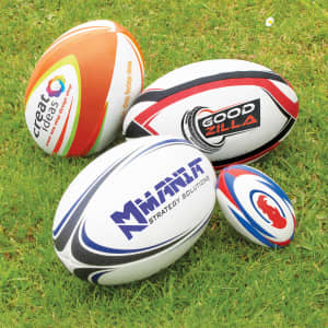 A collection of four rugby balls in various sizes and designs, featuring logos and branding.
