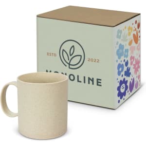 A coffee mug in a light beige colour, displayed next to a floral-patterned box featuring a logo.