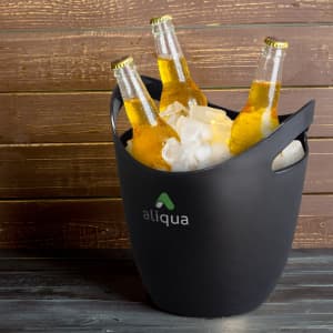A black ice bucket filled with ice and three bottles of beer. It features a logo.