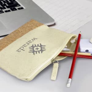 A cream and cork pencil case containing pens, pencils, and a small eraser, with a logo on the front.