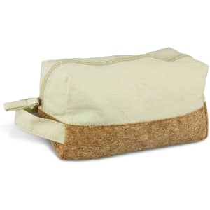 A toiletry bag in cream fabric with a cork base, featuring a zip closure and a side handle.