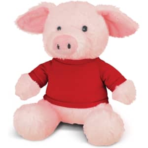 A pink pig plush toy wearing a red shirt, with soft texture and large ears, sitting upright.