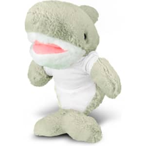 A grey-green shark plush toy with a white tummy and a smile, wearing a plain white t-shirt. It has a logo on it.