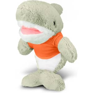 A plush shark toy in green with a white belly, wearing an orange shirt, featuring a logo on its chest.