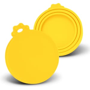 A set of yellow silicone reusable can lids in various sizes, featuring a circular design and a loop for easy handling.