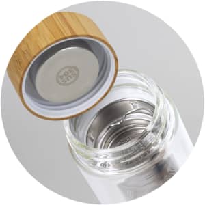 A drink bottle with a glass body, stainless steel infuser, and a bamboo lid. It features a logo on the interior.