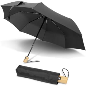 A black compact umbrella with a wooden handle, displayed both open and folded. It features a branding logo.