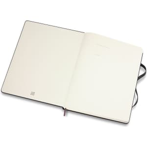 An extra-large, black Moleskine Classic hardcover notebook with blank pages and a ribbon marker.