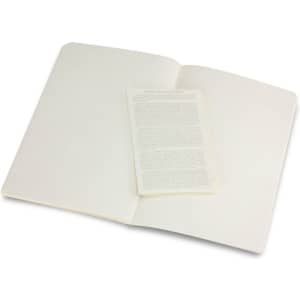 A large Moleskine Volant journal with blank pages, opened to display an inner leaflet. The cover is a neutral colour.