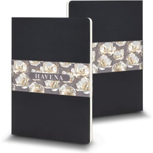 A large black Moleskine Volant journal featuring a floral design band. Includes a logo on the cover.