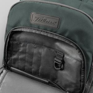 A green backpack features a textured fabric and a pocket with organisational sections and a hook. It has a logo.