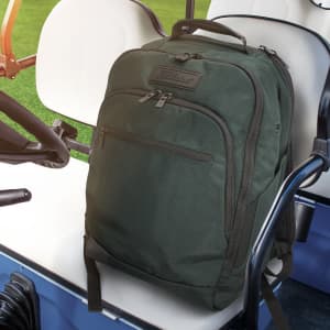 A dark green backpack with a textured finish and a branded logo, placed on a golf cart seat.