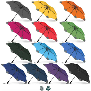 A collection of BLUNT Metro Umbrellas in various colours, including grey, yellow, orange, pink, red, green, blue, and black.