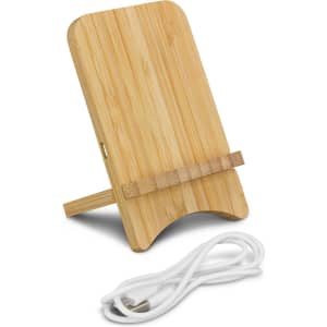 A bamboo wireless charging stand in a natural finish, featuring a cable and a simple strap for device support.