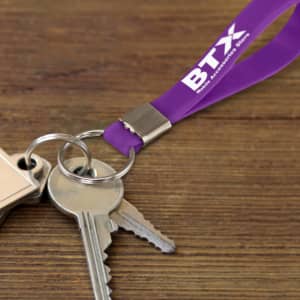 A purple silicone key ring attached to metal keys, featuring a logo on its surface.