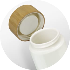 A drink bottle with a white ceramic body and a bamboo lid, featuring a smooth interior.