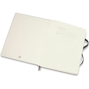 An extra-large, soft cover Moleskine notebook with blank pages and a ribbon bookmark, featuring a black exterior.