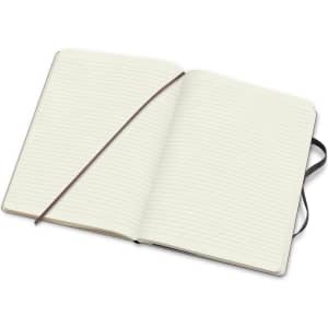 An extra-large soft cover Moleskine notebook featuring lined pages and a dark elastic closure.