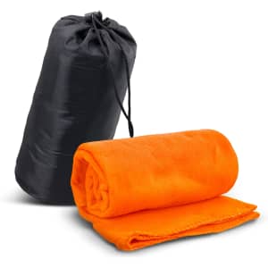An orange fleece blanket is rolled up beside a black carry bag. The blanket features a neat edge finish.