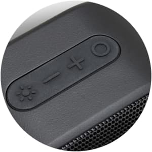 A close-up view of a black outdoor Bluetooth speaker's control panel, featuring buttons for volume and power.