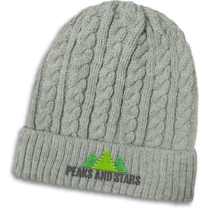 A grey knit beanie with a cable pattern and a logo featuring trees on the front.