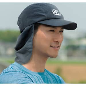 A navy Legionnaire hat with a brim and neck flap, worn by a smiling man outdoors.