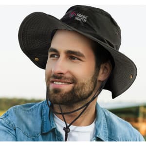 A black oilskin wide brim hat with a logo, featuring a drawstring and a textured brim, worn by a smiling man.