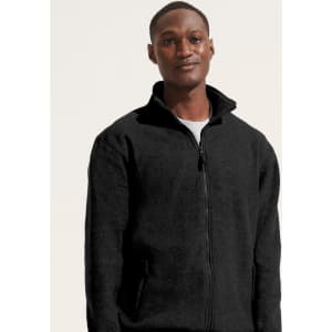 A man wearing a black polar fleece jacket with a zip and pockets, featuring a logo.