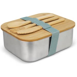 A stainless steel lunch box with a bamboo lid and cutlery, secured with a teal strap.