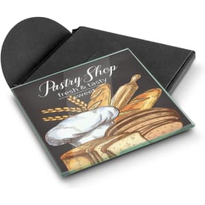 A square glass coaster featuring a colourful pastry shop illustration, presented in a black sleeve.