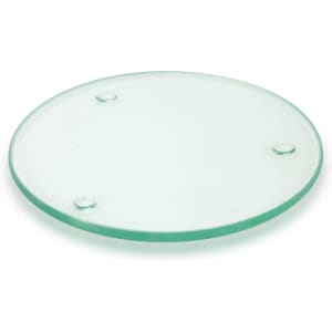 A round, transparent glass coaster with three small feet for stability.