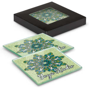 A set of two square glass coasters in green with intricate patterns, contained in a black box.