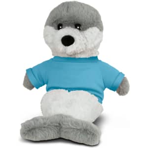 A plush seal toy with a grey and white body, wearing a blue T-shirt. It has a logo on its shirt.