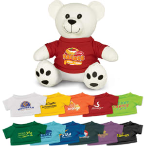 A plush toy bear in white with a red shirt, surrounded by various coloured T-shirts in different sizes.