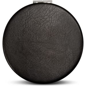 A round, black compact mirror featuring a textured surface and a metal clasp. The product has a simple design.