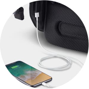 A black backpack with a cable connecting to a smartphone, showcasing a USB charging feature.