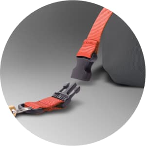 A close-up of a grey backpack strap with an orange attachment clip and buckle. The backpack features a logo.