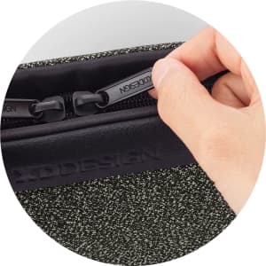 A hand grips the zipper of a textured green Urban Belt Bag, featuring a logo on the side.