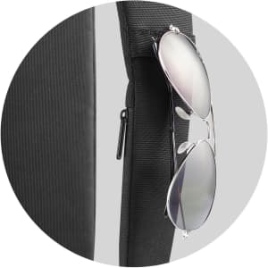A black product with sunglasses hanging from it, featuring a zippered compartment and a textured surface.