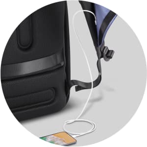 A black gym bag with a charging cable and a smartphone connected, featuring a textured surface and adjustable strap.