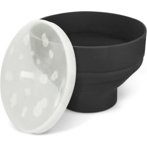 A black silicone microwave popcorn popper with a transparent lid featuring white spots.