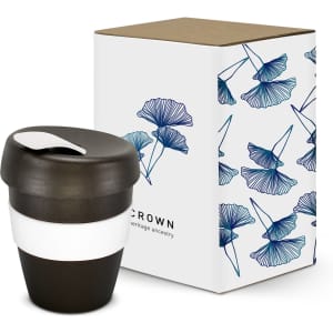 A drink bottle in black with a white band, next to a floral-patterned box. The bottle has a lid and a logo.
