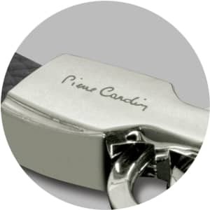 A close-up of a silver key ring with a black strap, featuring a logo.