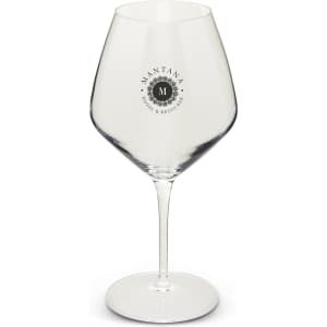 A clear glass wine glass with a large bowl and a long stem, featuring a logo on one side.