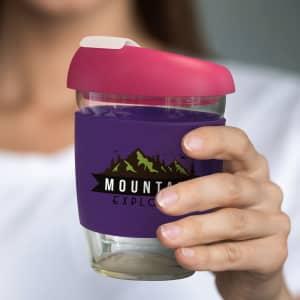 A drink bottle featuring a transparent borosilicate design, with a pink lid and a purple silicone sleeve.